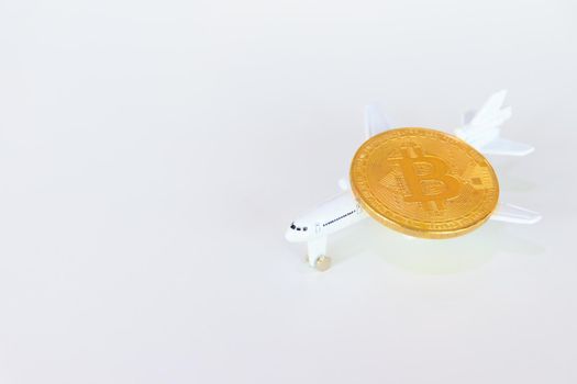 bitcoin coins above model of passenger plane  over white on black background. with copy space add text Top view