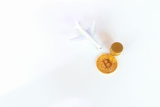 bitcoin coins and  and model of passenger plane  over white on black background. with copy space add text Top view