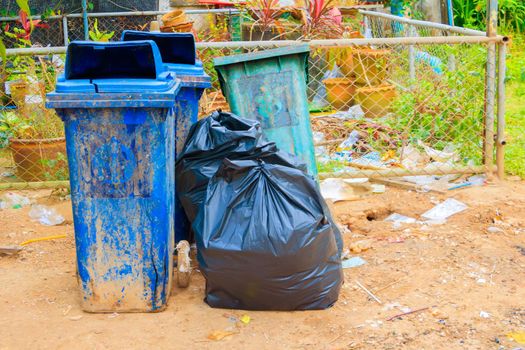 pile black garbage bag plastic and four dustbin dirty roadside in the city with copy space add text