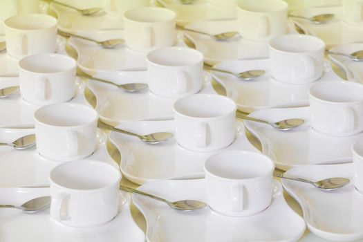 white coffee cup row with saucer and spoon on table