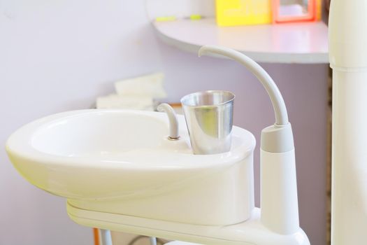 glass chromium on Sink medical equipment dentist Close up, ceramic spittoon and water filler in Clinic