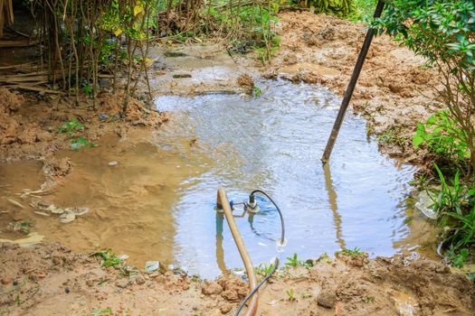 water flow broken pipe On the floor in garden copy space add text