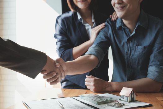 Young Asian Couple shaking hands with Estate agent after contract signature. Real Estate concept