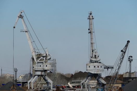 River port. The factory by the river. Sand mining. A crane and special equipment for loading sand. High quality photo