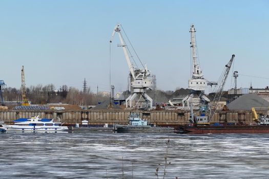 River port. The factory by the river. Sand mining. A crane and special equipment for loading sand. High quality photo