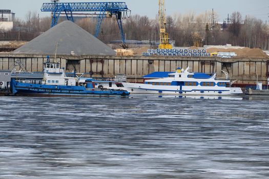 River port. The factory by the river. Sand mining. A crane and special equipment for loading sand. High quality photo