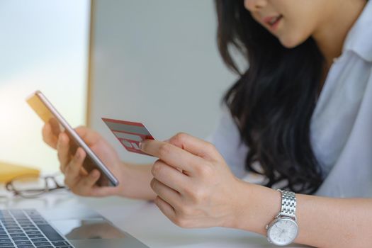 Online Shopping. Asian woman typing credit card information by laptop for shopping online