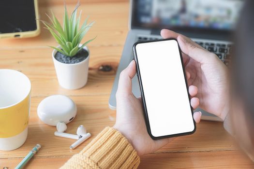 Asian woman holding smartphone with blank screen frameless modern design. Technology concept