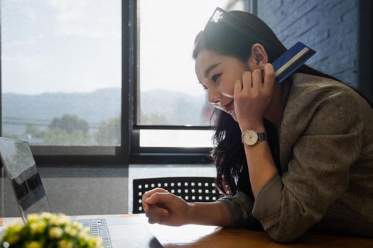 Online Shopping. Asian woman typing credit card information by laptop for shopping online