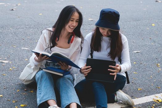 Two students are sitting in university during reading a book and communication. Study, education, university, college, graduate concept