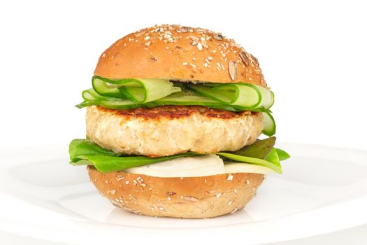 Fishburger fish burger with cod cutlet cucumber lettuce goat cheese dzatziki tartarus sauce and grain cereal bread on plate isolated on white background