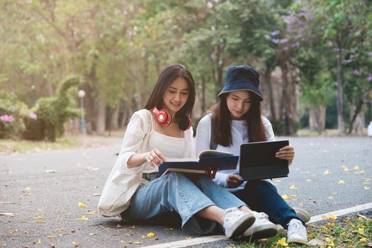 Two students are sitting in university during reading a book and communication. Study, education, university, college, graduate concept