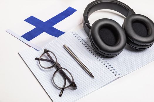 Learning foreign languages in Finland with audio recordings and headphones. Notepad, glasses, pen.
