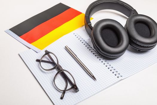 Learning foreign languages in Germany with audio recordings and headphones. Notepad, glasses, pen.