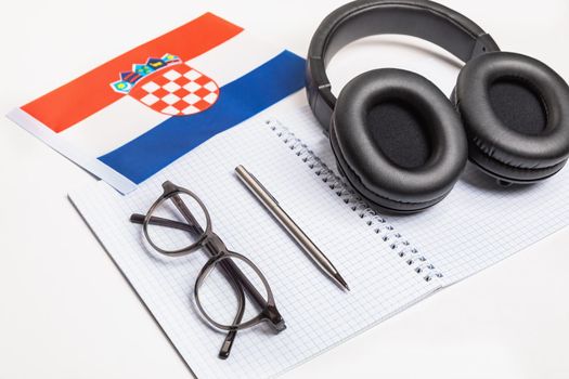 Learning foreign languages in Croatia with audio recordings and headphones. Notepad, glasses, pen.