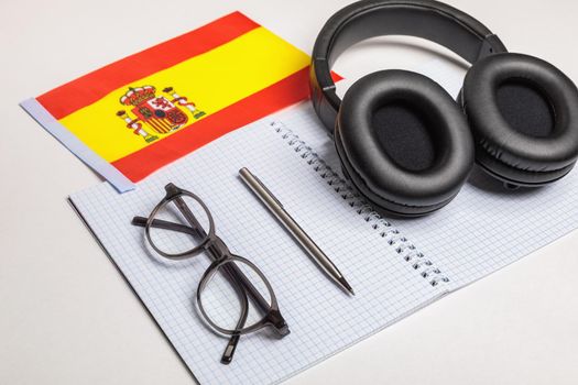 Learning foreign languages in Spain with audio recordings and headphones. Notepad, glasses, pen.