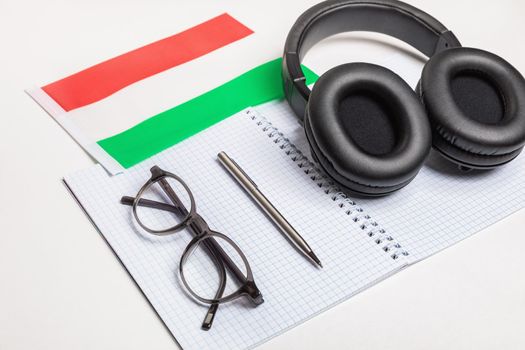 Learning foreign languages in Hungary with audio recordings and headphones. Notepad, glasses, pen.