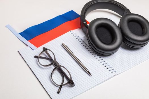 Learning foreign languages in Russia with audio recordings and headphones. Notepad, glasses, pen.