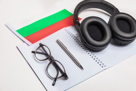 Learning foreign languages in Bulgaria with audio recordings and headphones. Notepad, glasses, pen.