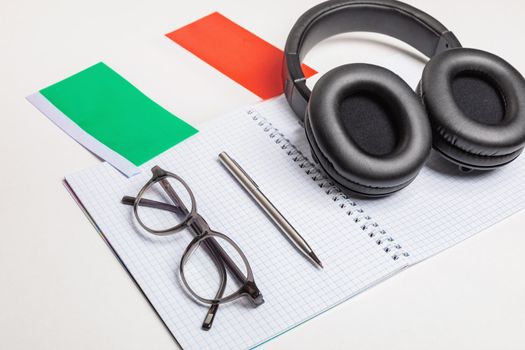 Learning foreign languages in Italy with audio recordings and headphones. Notepad, glasses, pen.