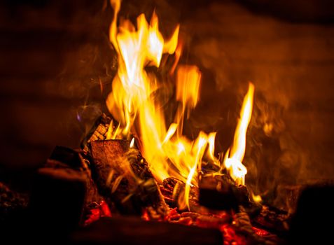 A campfire burns in the snow at night in the snow in the cold winter. The flame of the fire warms and illuminates. Flame, background