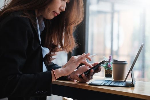 Closeup of Woman with a finger on the screen using a mobile phone in the office. Business woman hand using mobile smart phone and reading message via application