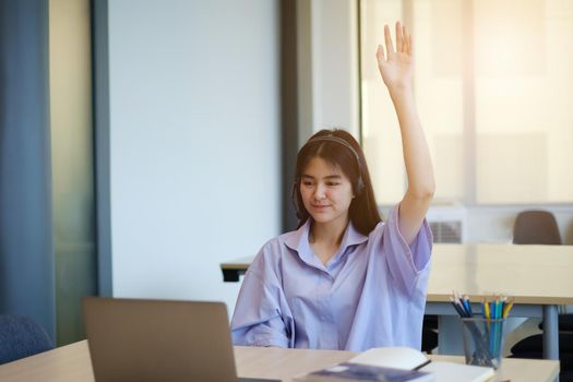 Happy student wave hand and have question while learning online sitting in living room from home by laptop computer. Social distancing.stay home. New normal.Covid-19 coronavirus