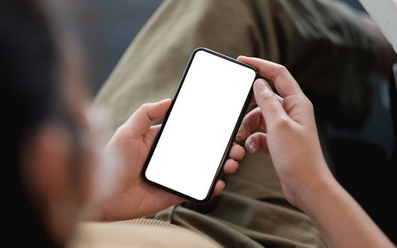 Top view Woman sitting and holding blank screen mock up mobile phone