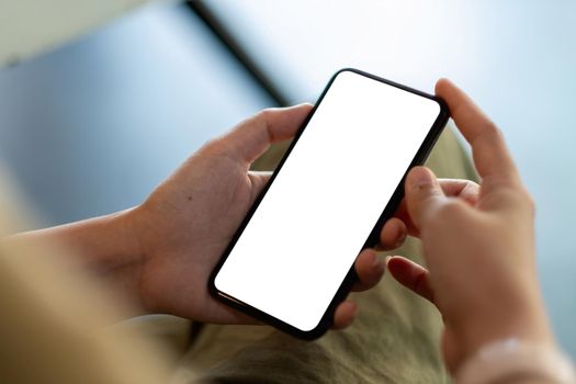 Mockup image of a woman holding and using black mobile phone with blank desktop screen