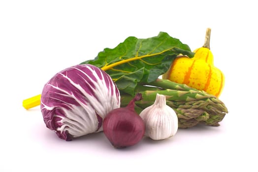 Assortment of fresh colorful including leaf beet, asparagus, radicchio salad, onion and garlic isolated on white background
