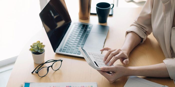 Close up view of bookkeeper or financial inspector hands making report, calculating or checking balance. Home finances, investment, economy, saving money or insurance concept.