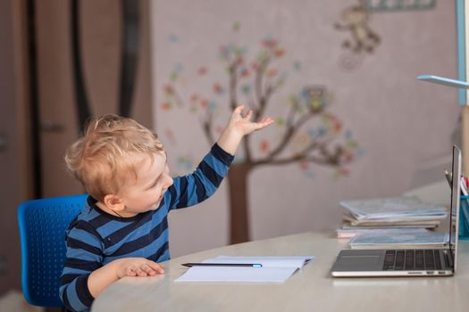 Cute baby boy having video class or video chat with grandparents. Quarantine isolation distance communication concept