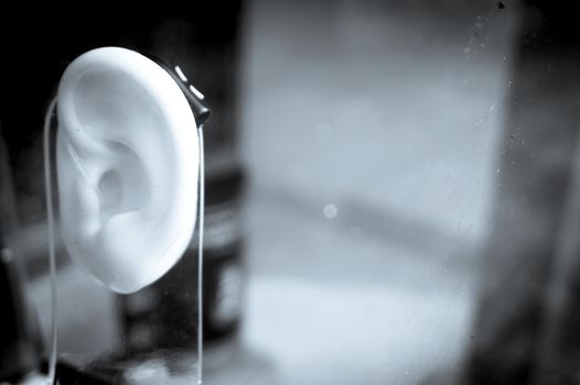 Plastic ear with modern hearing aid. No people