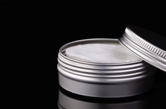 Silver metal containers for make-up removing tampons isolated on the black glass desk.