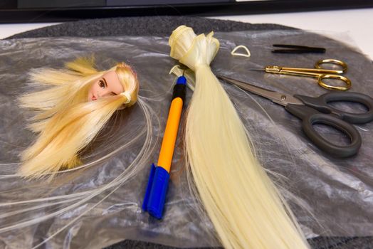 scissors and homemade tool on the table, how to make hair for a doll, hobby concept.