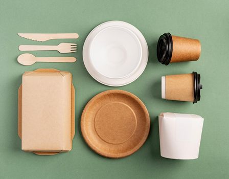 Knolling concept. Eco friendly zero waste disposable tableware top view flat lay on green background