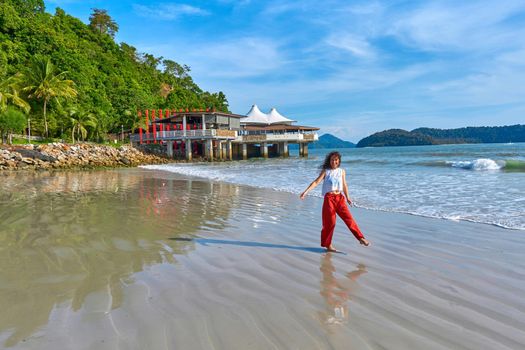 happy tourist woman enjoy travel on the central beach in Langkawi tropical island.