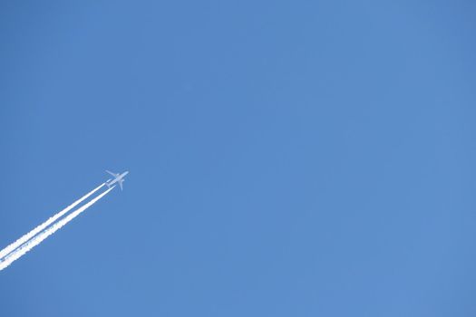 A jet plane in the sky. a double track from a jet plane in a blue sky. High quality photo
