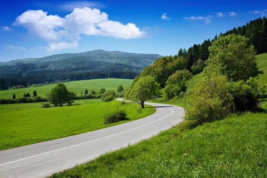 Beautiful summer mountain road and cloudy sky