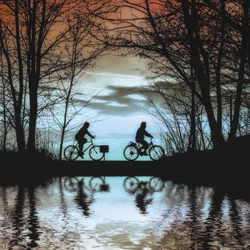 Silhouette man riding bike at sunset