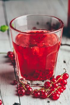 Table glass of infused water with fresh red currant