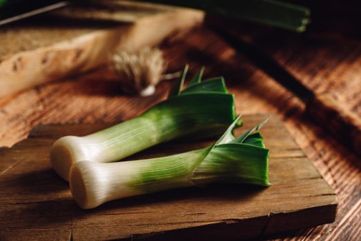 Fresh green leek on wooden cutting board