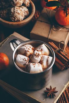 Rustic mug of hot chocolate with marshmallows in rustic setting