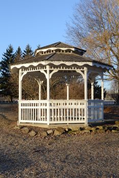 A white modern gazebo during the early springtime season.