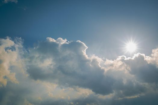 spring sun on blue sky with clouds at noon