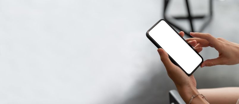 Mock up phone in woman hand showing white screen on top view.