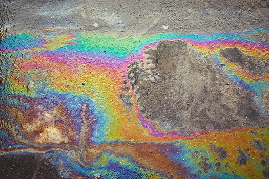iridescent spot of gasoline on pavement as Texture or Background