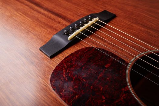 The bridge and strings of and acoustic guitar. Close up. Selective focus