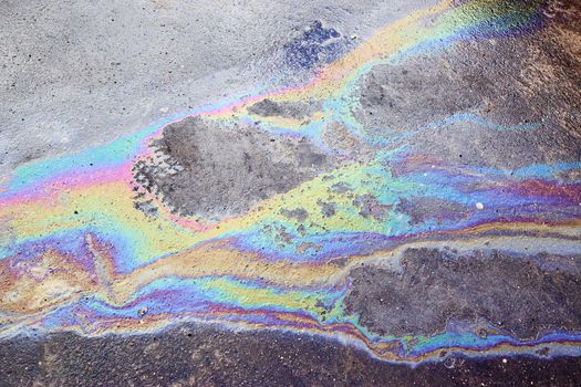 Oil stain on Asphalt, color Gasoline fuel spots on Asphalt Road as Texture or Background. Iridescent stains of gasoline.