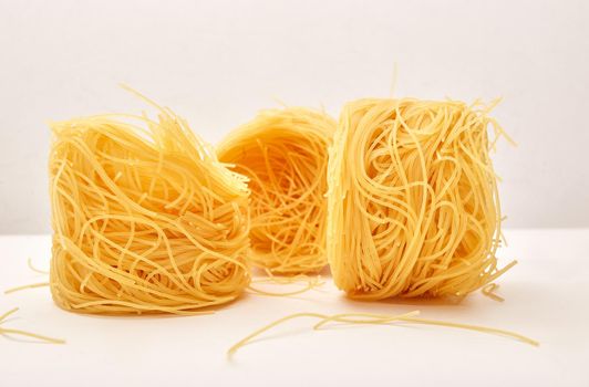 Italian egg pasta nest on white background